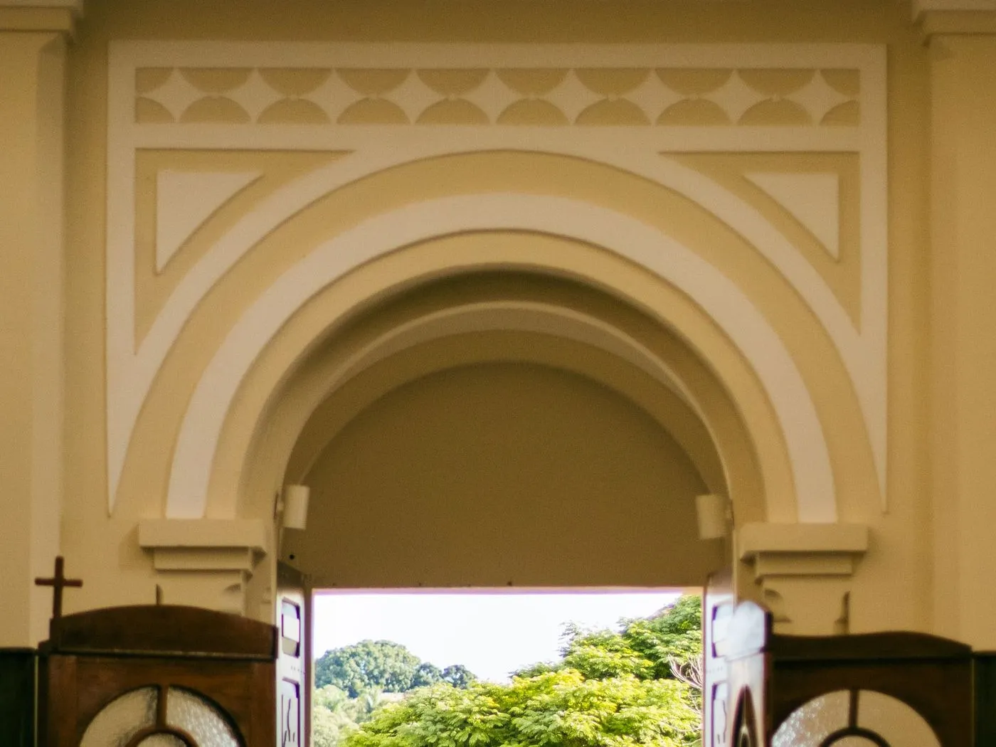 A church entrance seen from the pews, a TV above the doors showing Grace Community Church's building-fund goal and prayer times