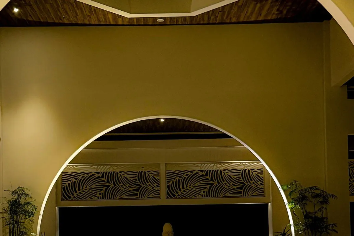 A warm arched hotel lounge with a wall TV showing Bella Vista Hotel's events board